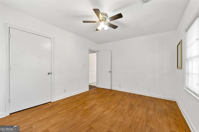 unfurnished bedroom featuring a ceiling fan, light wood-style flooring, and baseboards