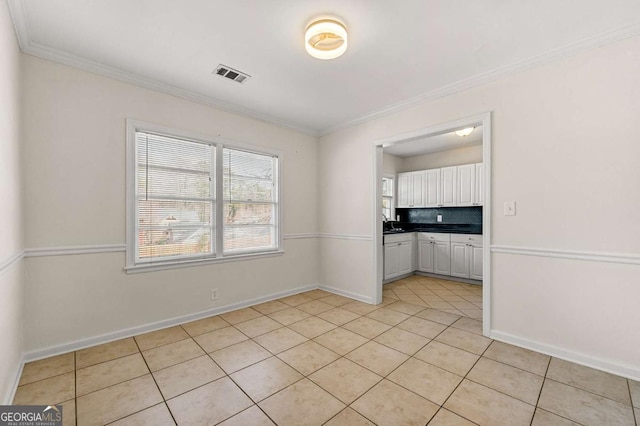 unfurnished room featuring ornamental molding, light tile patterned flooring, visible vents, and baseboards