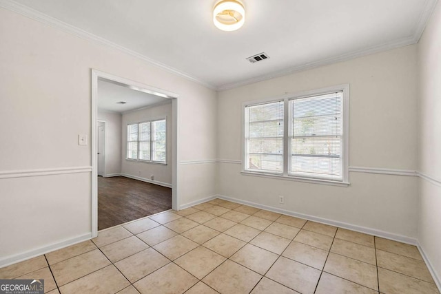 empty room featuring baseboards, light tile patterned flooring, visible vents, and crown molding