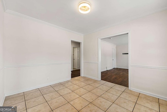 unfurnished room with ornamental molding, light tile patterned flooring, and baseboards