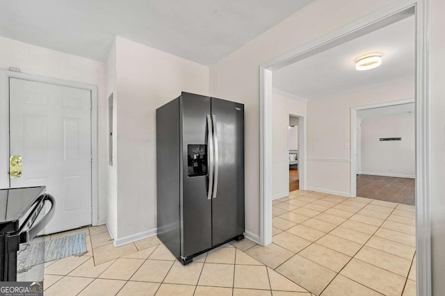 kitchen with light tile patterned floors, baseboards, crown molding, and stainless steel fridge with ice dispenser