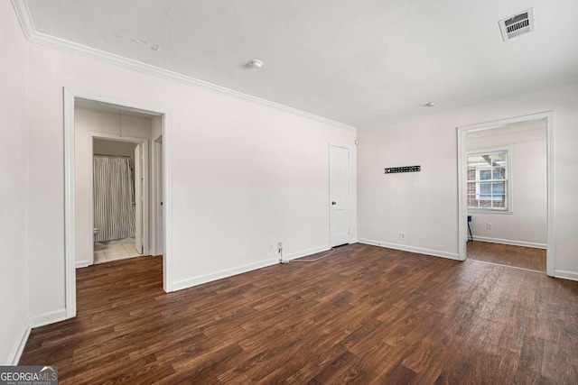 unfurnished room with visible vents, dark wood-style flooring, and crown molding