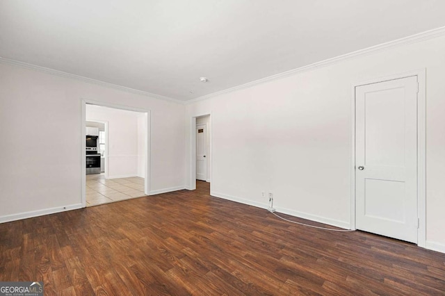 empty room featuring baseboards, dark wood finished floors, and crown molding