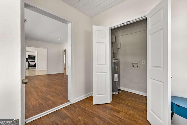 interior space with dark wood-style floors, water heater, and baseboards