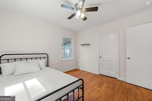 bedroom with light wood-style flooring, baseboards, and a ceiling fan