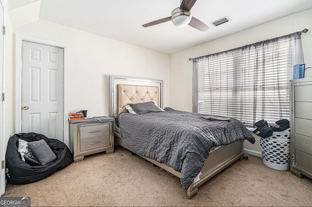 bedroom featuring ceiling fan, visible vents, and light colored carpet