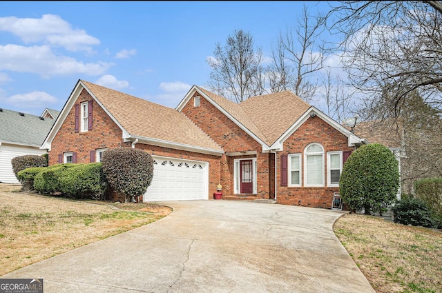 view of front of home with driveway, roof with shingles, an attached garage, a front lawn, and brick siding