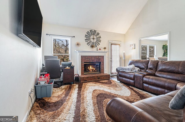 living room with carpet, high vaulted ceiling, plenty of natural light, and a fireplace