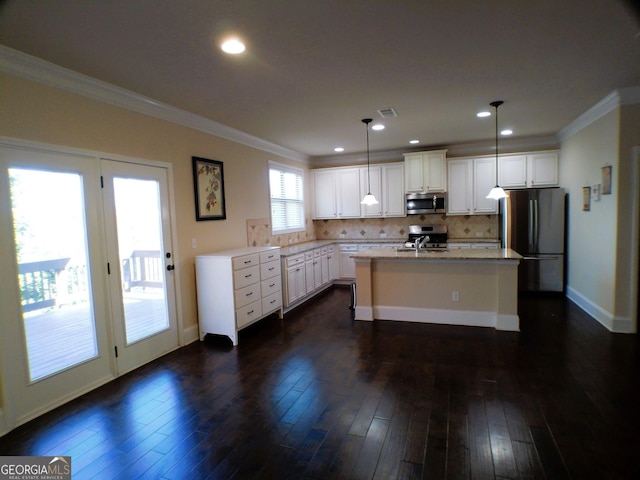 kitchen featuring stainless steel appliances, tasteful backsplash, ornamental molding, dark wood-type flooring, and white cabinets