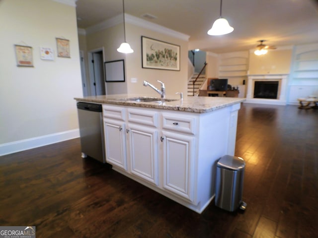 kitchen featuring a fireplace with raised hearth, dark wood-style flooring, a sink, dishwasher, and decorative light fixtures