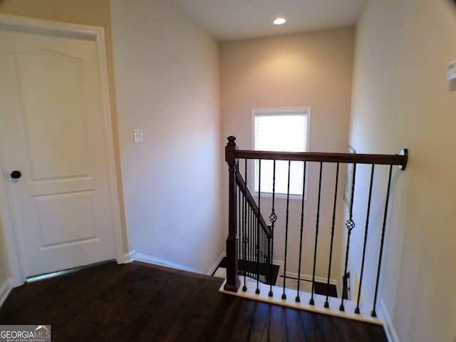 staircase featuring baseboards, wood finished floors, and recessed lighting