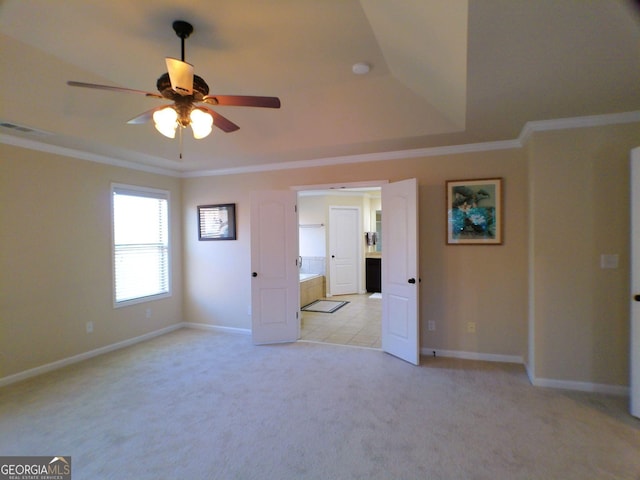 unfurnished bedroom featuring visible vents, baseboards, light colored carpet, a tray ceiling, and crown molding