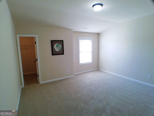 unfurnished room featuring carpet, visible vents, and baseboards