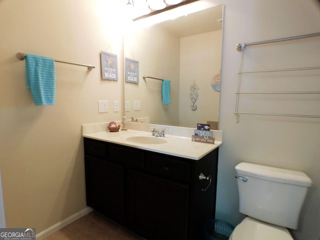 bathroom featuring baseboards, vanity, and toilet