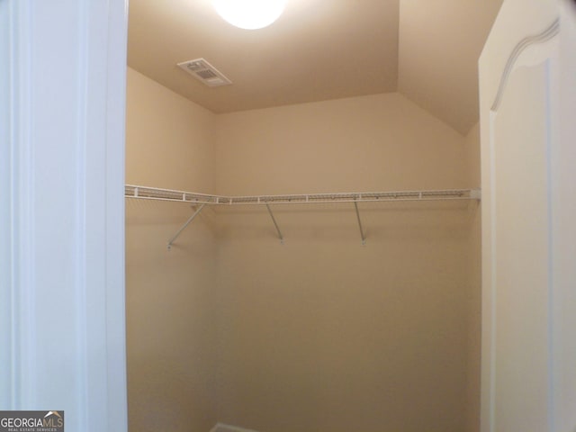 walk in closet with visible vents and vaulted ceiling