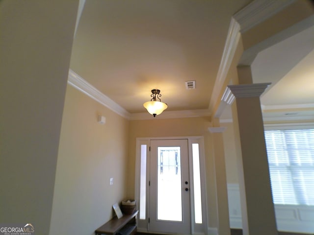 foyer entrance featuring ornate columns, visible vents, and crown molding