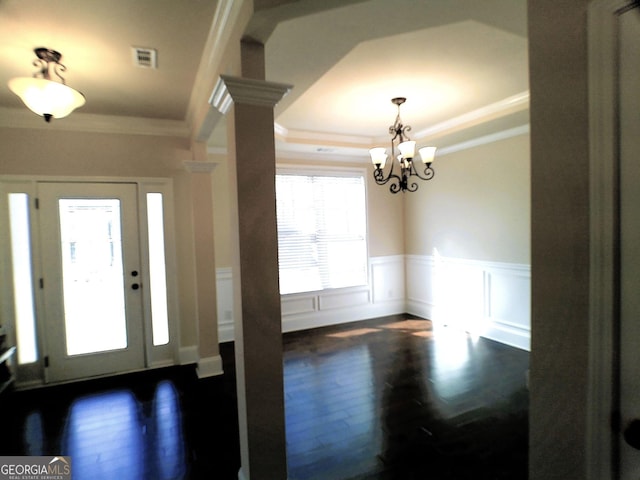 entryway featuring a wainscoted wall, visible vents, a raised ceiling, and crown molding