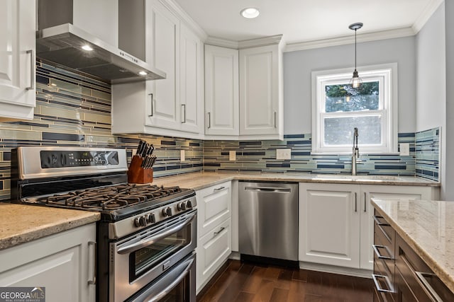 kitchen with stainless steel appliances, dark wood-style flooring, white cabinets, wall chimney exhaust hood, and crown molding