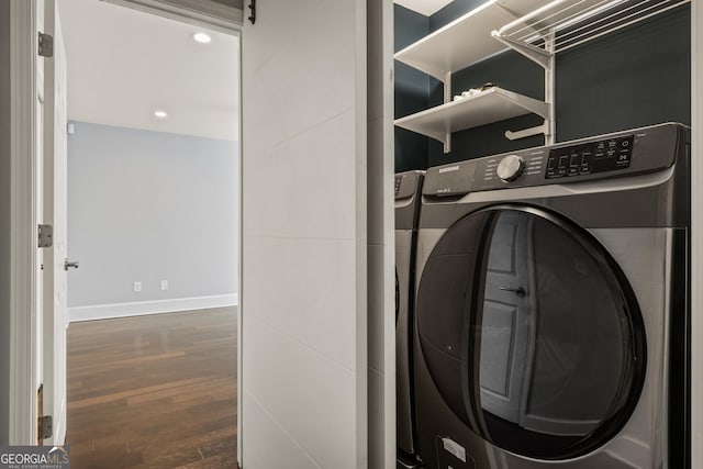 washroom with a barn door, wood finished floors, washer / dryer, laundry area, and baseboards