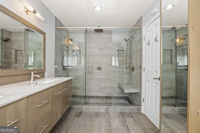 full bathroom with a shower stall and vanity