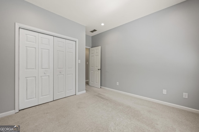 unfurnished bedroom with carpet, a closet, visible vents, and baseboards