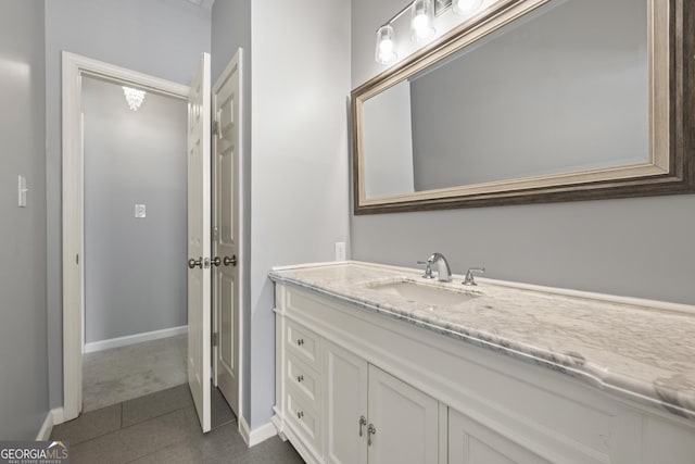 bathroom with tile patterned flooring, vanity, and baseboards