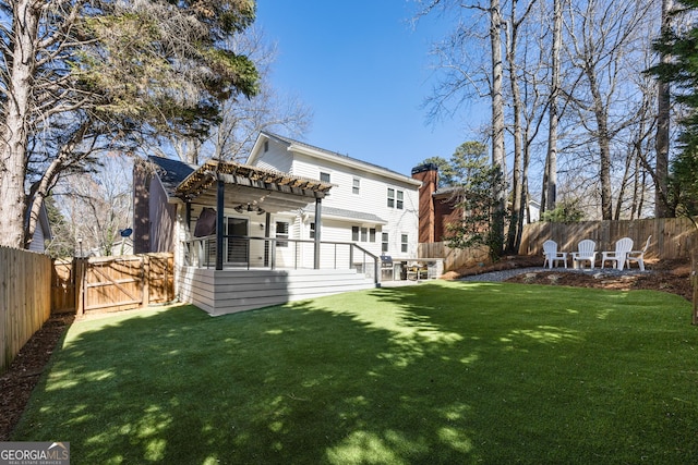 rear view of house with a yard, a fenced backyard, a gate, and a pergola