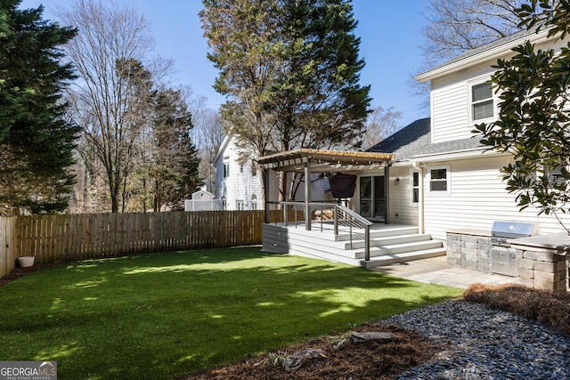 view of yard featuring a fenced backyard, a deck, an outdoor kitchen, and a pergola