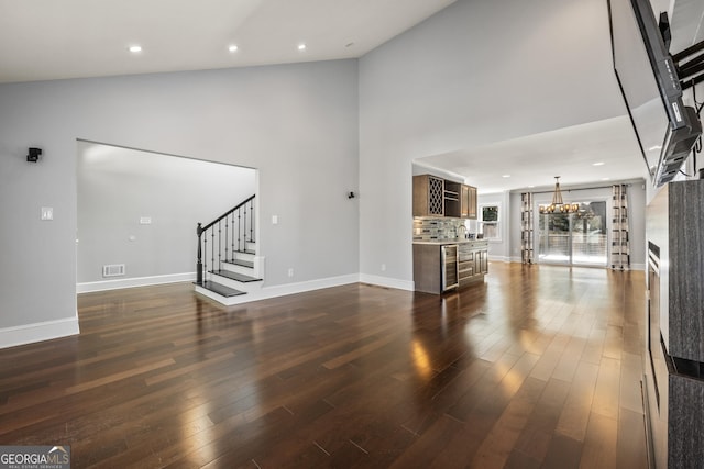 unfurnished living room featuring stairway, dark wood finished floors, visible vents, and baseboards