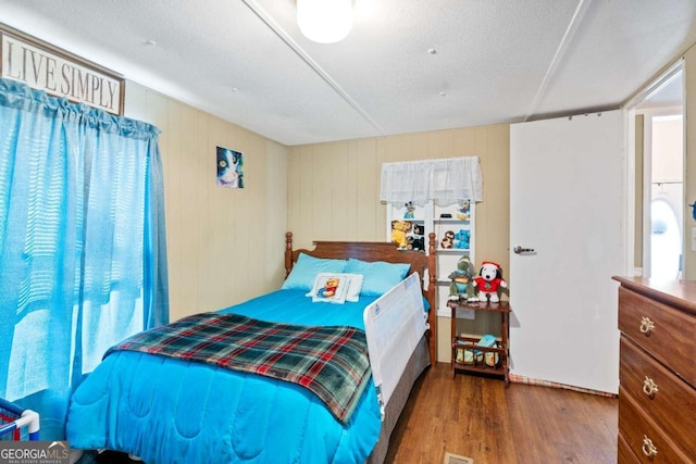 bedroom featuring dark wood-style floors and a textured ceiling