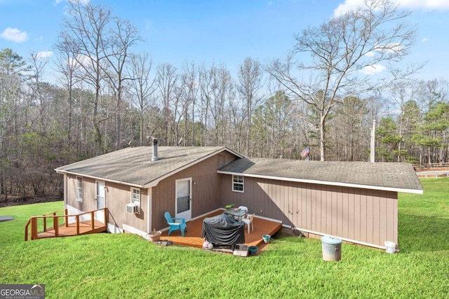 back of property featuring a wooden deck, roof with shingles, cooling unit, and a yard