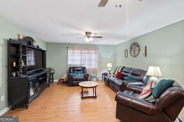 living area with light wood-style flooring, baseboards, and a ceiling fan