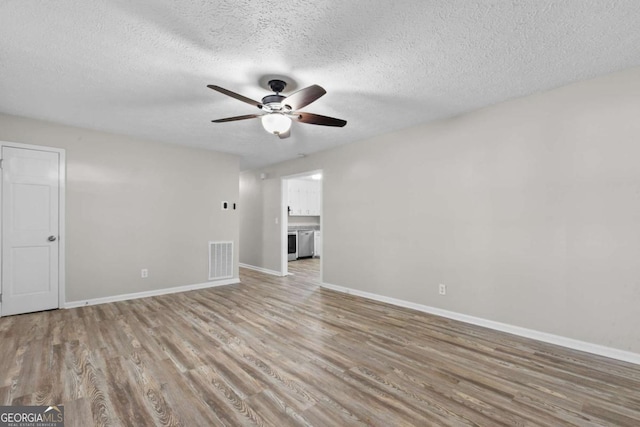 unfurnished living room featuring light wood finished floors, baseboards, visible vents, and a ceiling fan