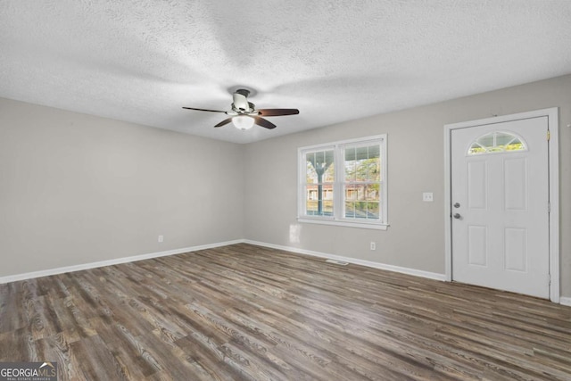 entryway with dark wood-type flooring, ceiling fan, a textured ceiling, and baseboards