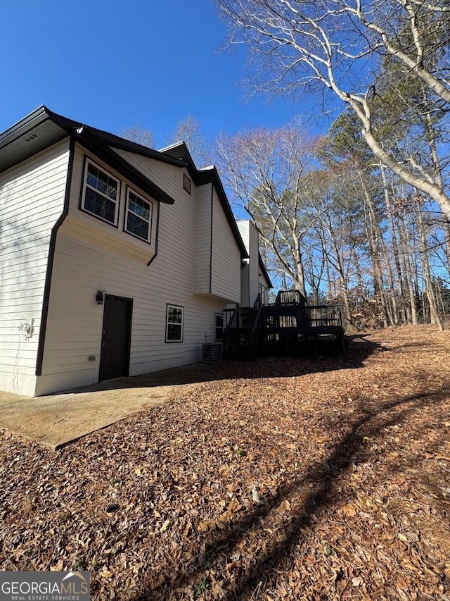 view of side of home featuring a patio and a wooden deck