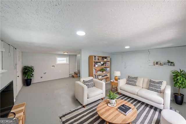 living area with concrete floors, a textured ceiling, and recessed lighting