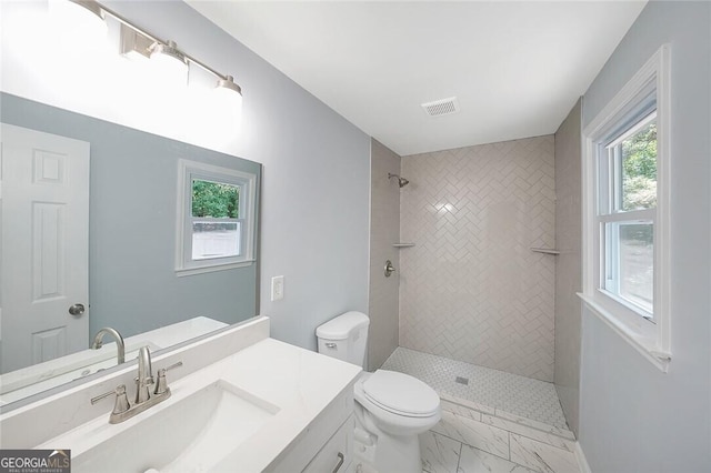 full bath with toilet, vanity, visible vents, marble finish floor, and tiled shower