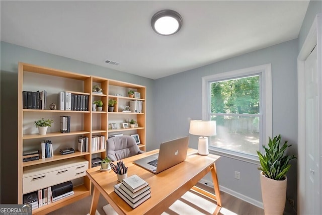 home office featuring wood finished floors, visible vents, and baseboards