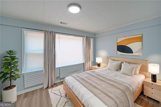 bedroom with visible vents and light wood-style flooring