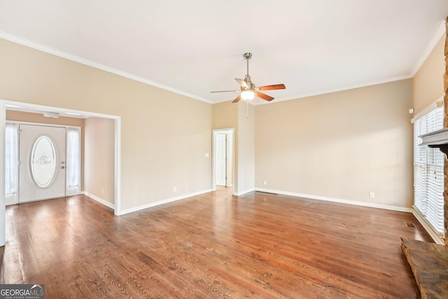 unfurnished living room with a brick fireplace, crown molding, baseboards, and wood finished floors