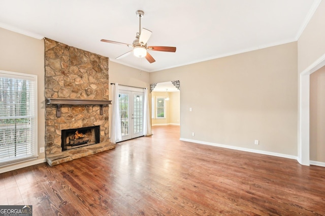 unfurnished living room featuring baseboards, crown molding, and wood finished floors