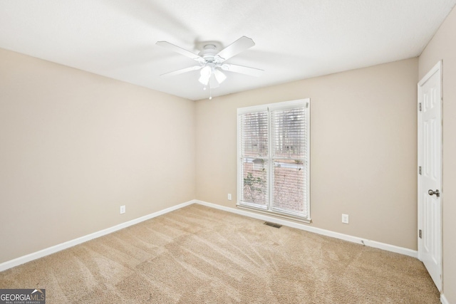 spare room with visible vents, carpet floors, a ceiling fan, and baseboards