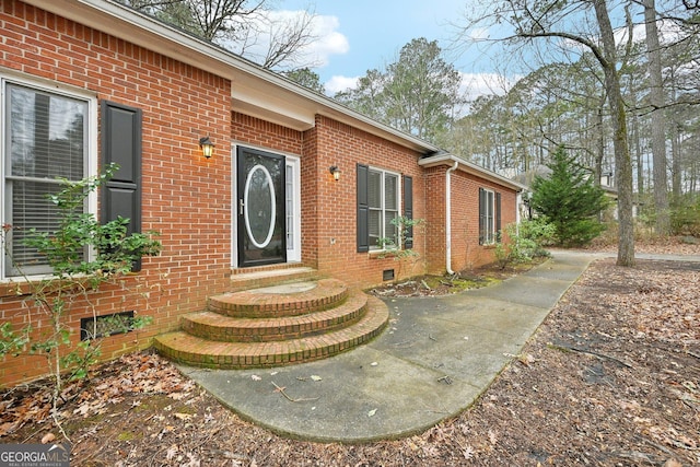 doorway to property with crawl space and brick siding