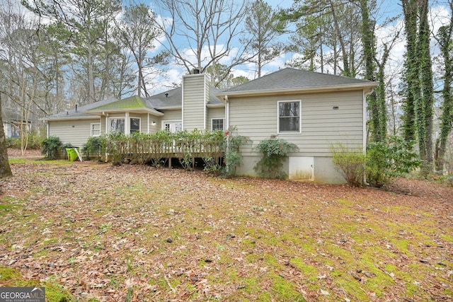 rear view of property featuring a deck and a chimney