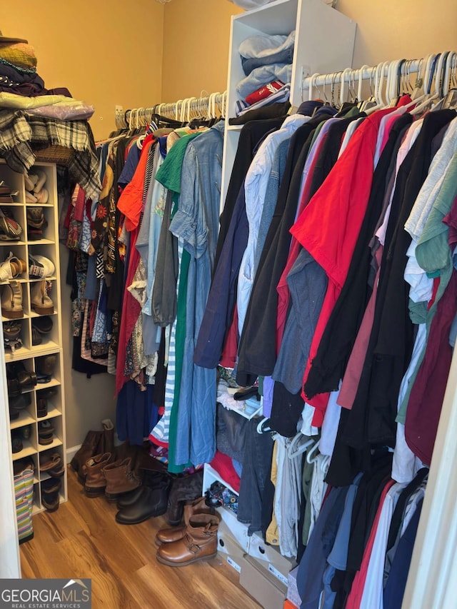 walk in closet with wood finished floors