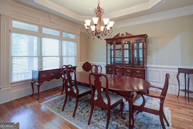 8440 Woodland Brooke Trl, Cumming, GA 30028 - dining area with a chandelier, a decorative wall, wood finished floors, crown molding, and wainscoting