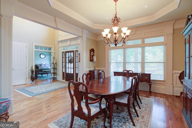 8440 Woodland Brooke Trl, Cumming, GA 30028 - dining space with a tray ceiling, a chandelier, wood finished floors, and ornamental molding