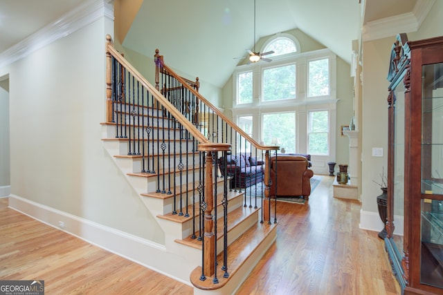 8440 Woodland Brooke Trl, Cumming, GA 30028 - staircase with a ceiling fan, wood finished floors, high vaulted ceiling, baseboards, and crown molding