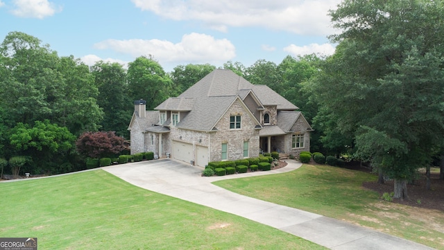 8440 Woodland Brooke Trl, Cumming, GA 30028 - french country home featuring a garage, driveway, stone siding, a front lawn, and a shingled roof