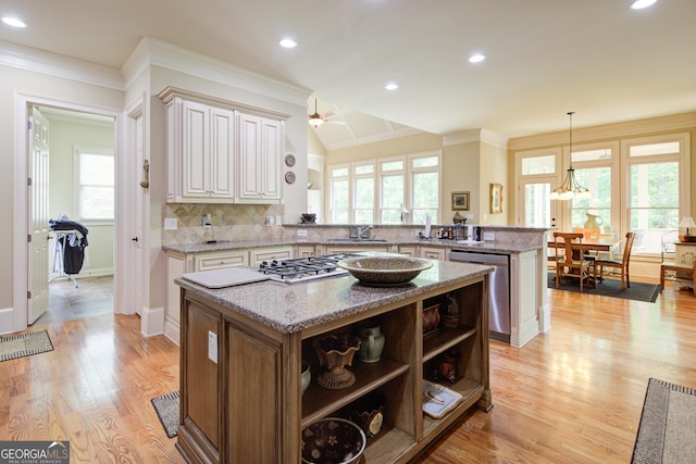 8440 Woodland Brooke Trl, Cumming, GA 30028 - kitchen with a peninsula, stainless steel appliances, a center island, open shelves, and healthy amount of natural light